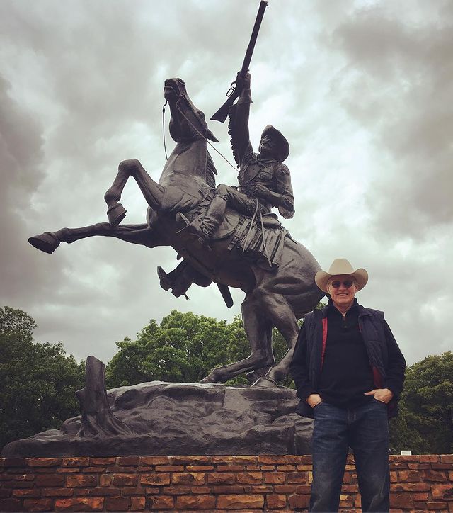 Bruce Boxleitner in a white hat, black jacket and noir jeans.